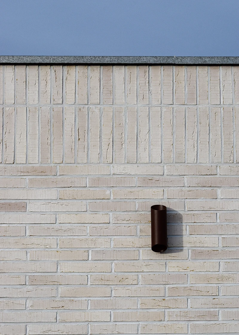 Détail d’une façade en briques blanches avec applique murale